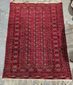 Afghan bokhara style red ground rug with three rows of 14 elephant foot guls, multiple geometric