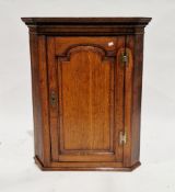 George III oak hanging corner cupboard with dentil moulding to cornice, single panel door opening to