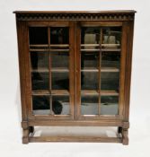 1930's/40's oak display cabinet, the two glazed doors opening to three adjustable shelves, on turned