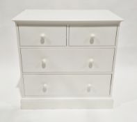 Modern white laminate chest of two short and two long drawers, with white handles, on a plinth base,