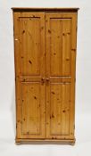 Pair of modern pine wardrobes, each with two panel doors opening to a shelf and hanging space, on