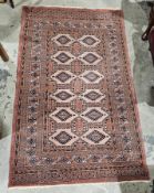 Eastern salmon ground rug with one row of five hexagonal medallions and two rows of six hooked