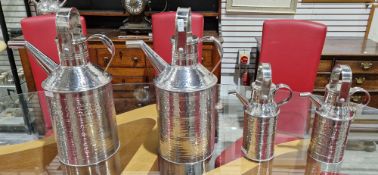 Two pairs of polished stainless steel travelling showman or fairground milk cans, all with swing