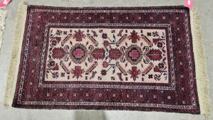 Eastern cream ground rug with two central geometric and floral medallions on stylised animal and