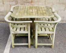 Weathered teak garden table with four nesting chairs, the table with a shaped square top, on a