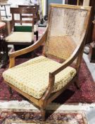 Early 20th century open armchair with square bergère back and seat, on turned tapering front legs,
