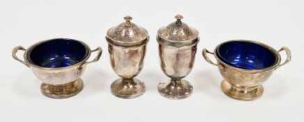Pair of George V silver open salts with blue glass liners and a matching pair of silver pepperettes,