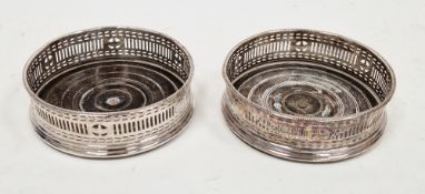 Pair of silver plated and mahogany wine bottle coasters with pierced sides, 13cm diameter (2)