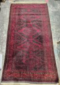 Large Eastern red ground rug with three lozenge medallions and single geometric medallion on half