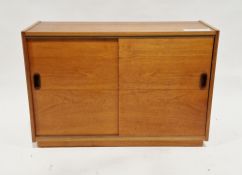 Mid-century teak low cupboard/sideboard having two panel sliding doors, on a plinth base, 64cm