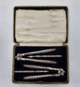 Early 20th century cased set of silver plated nutcrackers and nut picks, stamped with mirrored