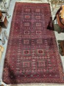 Large Eastern red ground rug with two rows of seven rectangular medallions on floral field, multiple