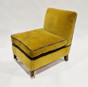 Easy chair upholstered in a mustard-coloured fabric with blue piping, having a loose cushion seat