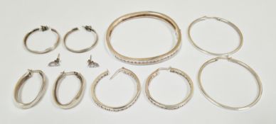 Collection of silver jewellery including channel CZ set hinged bracelet, four pairs of hoop earrings