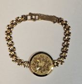 9ct yellow gold locket bracelet, the circular photo locket with floral and engine turned