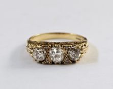 18ct gold three-stone graduated diamond ring, the old cut diamonds interspersed by four small