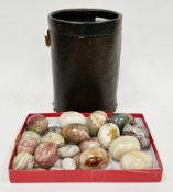 16 carved and polished stone eggs, largest 17cm long in a leather wastepaper basket