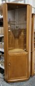 Ercol Windsor ash corner cabinet, model 2138 with smoked glass door opening to adjustable glass