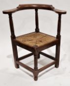 18th century-style oak corner chair, the curved top rail with three turned supports, square rush