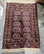 Eastern brown ground rug with two rows of five elephant foot guls on geometric field, multiple