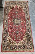 Eastern wool red ground rug with central floral medallion on floral field, floral spandrels,