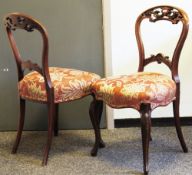 Set of four Victorian mahogany balloonback dining chairs with carved pierced scrolling top rails,