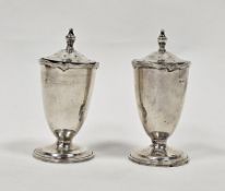 Pair of silver pepperettes, hallmarks rubbed, of plain baluster form with finials and reeded