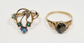 14k yellow gold and black star sapphire ring, the oval cabochon showing asterism, foliate scroll