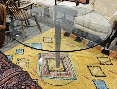 Contemporary glass topped dining table of circular form, metal central supports on a circular