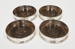 A set of four George III armorial silver and mahogany bottle coasters, hallmarked London, 1810, each