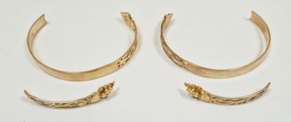 Pair of 10k yellow gold torque bracelets, both broken, with part foliate pierced design, approximate