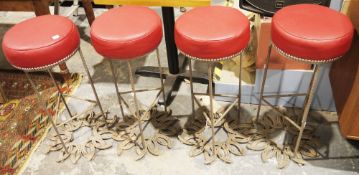 Set of four circular bar stools, each with studded padded seats upholstered in red leather-effect
