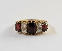 18ct gold, garnet and diamond ring, the three graduated mix cut garnets interspersed by two pairs of
