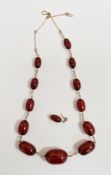Cherry amber bakelite bead necklace, comprising twelve graduating beads with yellow metal link