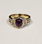 18ct yellow gold, ruby and diamond dress ring, the oval cabochon ruby flanked either side by three