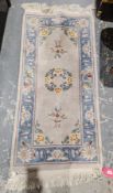 Chinese super wash pink ground rug with central floral motif, floral spandrels and single floral
