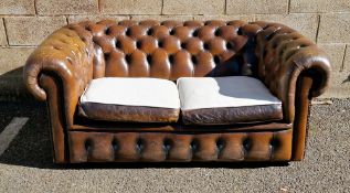 Brown buttoned leather two-seater Chesterfield sofa, the two cushion seats with replaced beige