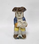 English Prattware Toby jug and cover, circa 1800 to 1820, modelled seated holding a jug of foaming