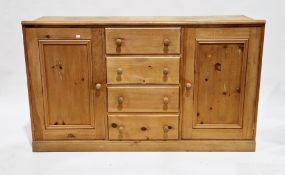 Modern pine dresser base comprising a central bank of four drawers, flanked either side by