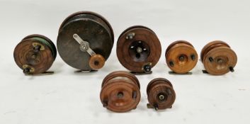 Six mahogany and brass strap back fishing reels, all with brass feet, ranging from 5