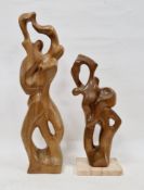Two wooden abstract sculptures depicting figures dancing, both signed 'piper' to the back, one on