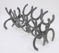 Two magazine racks constructed from horseshoes (2)