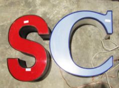Two vintage illuminated letters S in red and C in blue and two large modern circular wall clocks