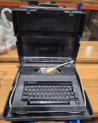 Silver Reed electric typewriter contained within black plastic case