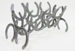 Two magazine racks constructed from horseshoes (2)