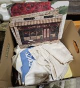 Box containing small collection of table linen including circular tablecloth and some napkins, place
