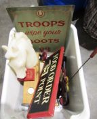 Large candle in the form of a horse's head, a metal sign reading Troops Wipe Your Boots, a wooden