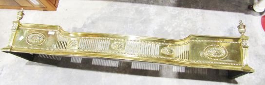 Elaborately decorated brass fire fender in the classical style, pillared corners with urn finials,