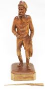 In the manner of Paul Emile Caron, a pine carved figure of game keeper carrying a rifle and