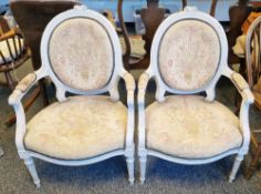 Pair of French Louis XVI-style painted elbow chairs, the oval backs with foliate and floral carved
